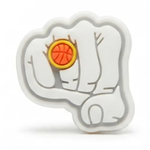 Jibbitz poing blanc fluo portant une bague dorée ornée d'un ballon de basket orange