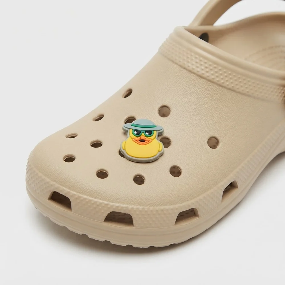Jibbitz canard chapeau et lunettes fluo clipsé sur une Crocs