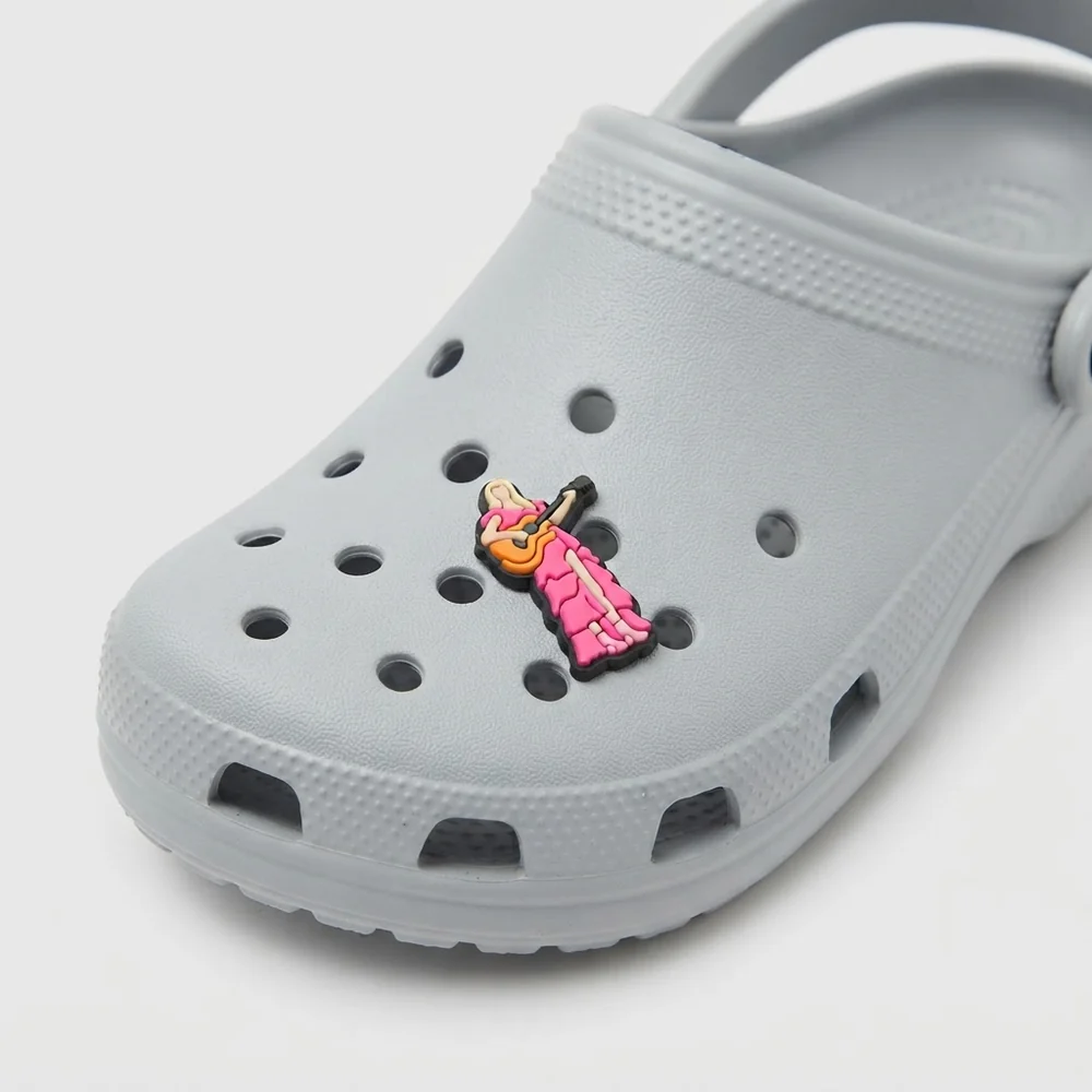 Jibbitz chanteuse en robe rose avec guitare, clipsé sur une Crocs