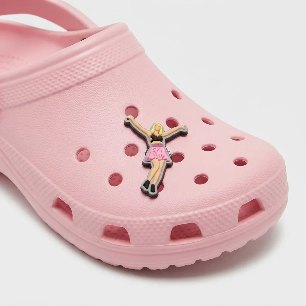 Jibbitz chanteuse jupe rose bras levés, version fluo, sur une Crocs