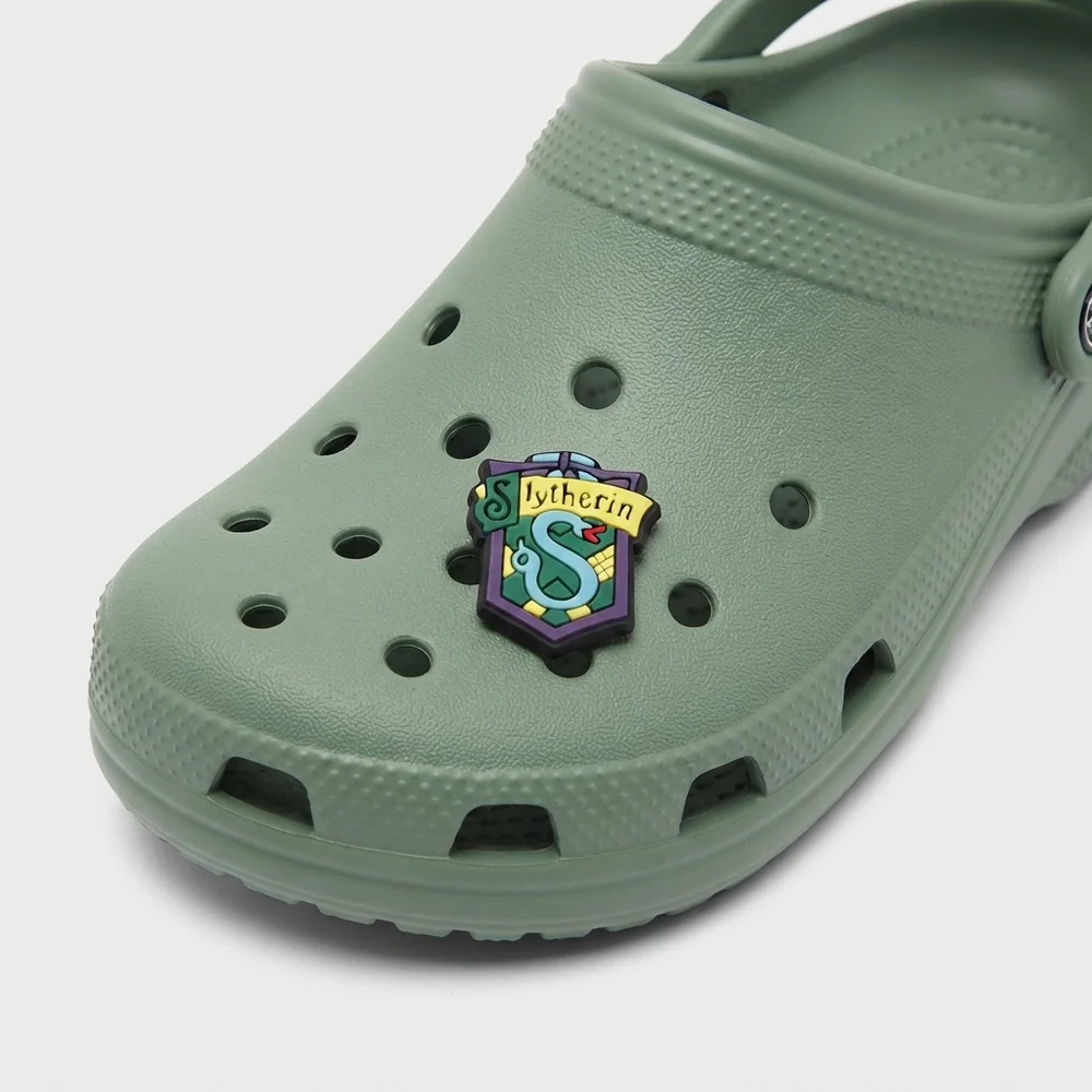 Charm blason Serpentard clipsé sur une Crocs vert sauge