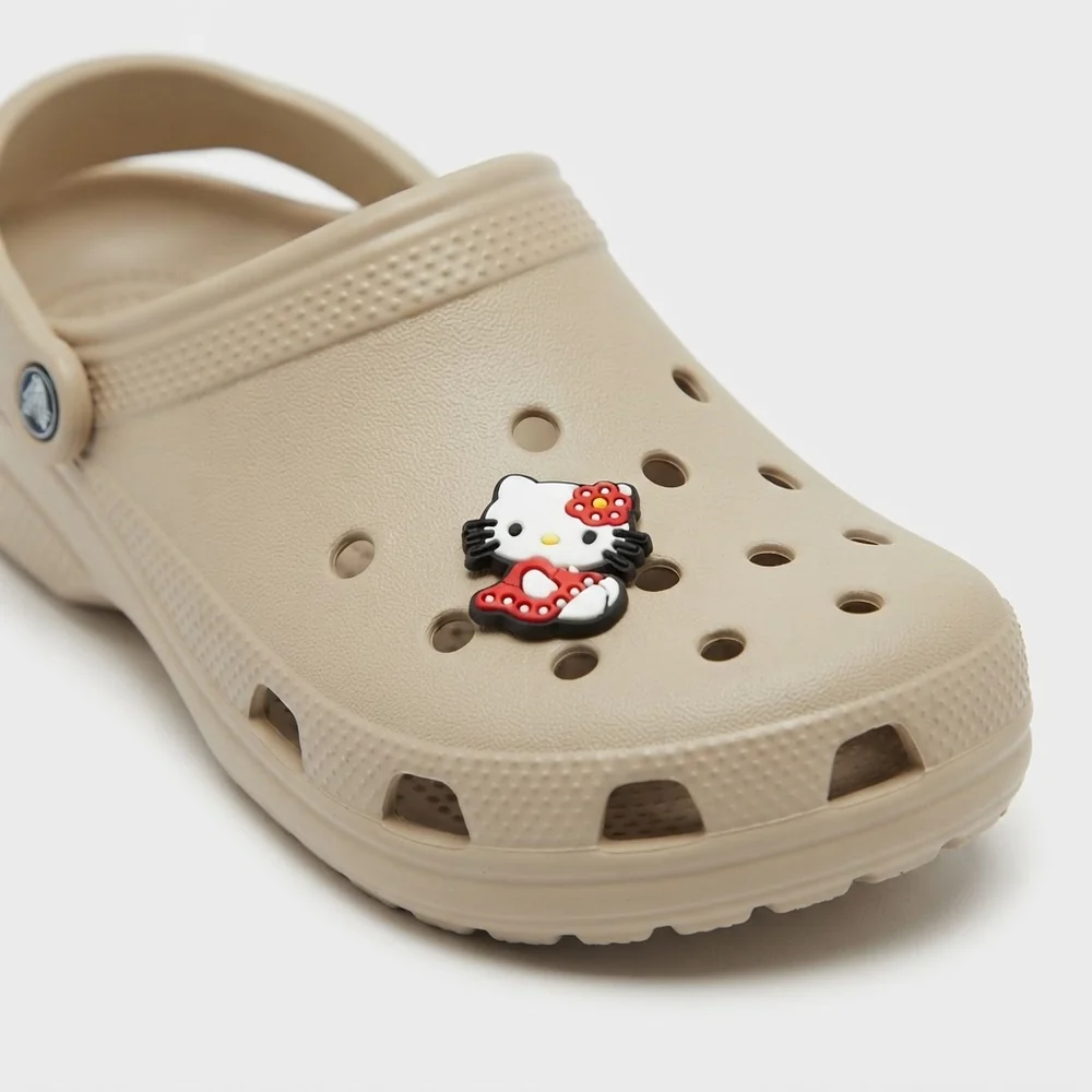 Jibbitz Hello Kitty à la fleur et robe à pois sur une Crocs beige