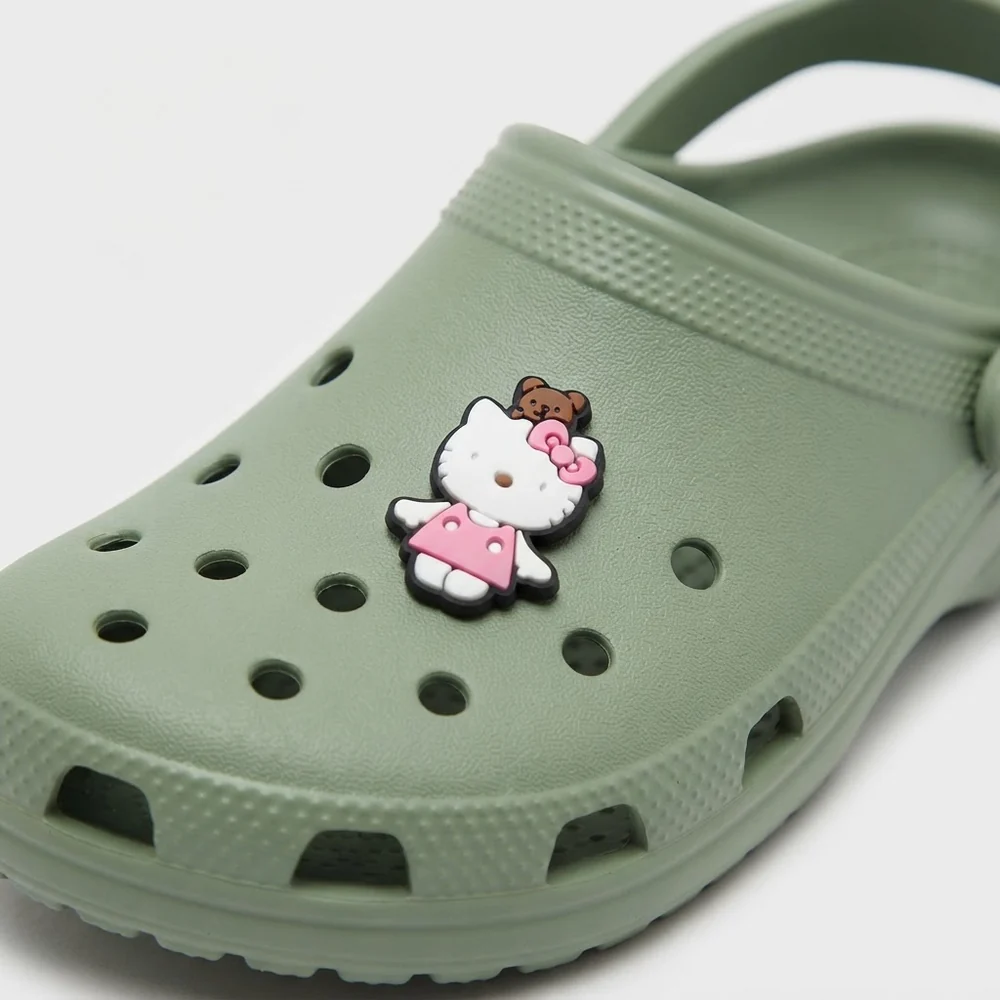 Jibbitz Hello Kitty robe rose et ourson sur une Crocs vert sauge