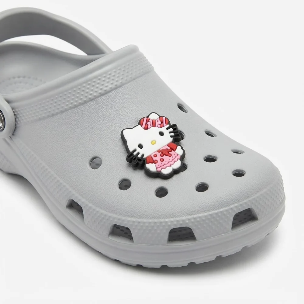 Jibbitz Hello Kitty crème en robe rose à pois sur une Crocs grise
