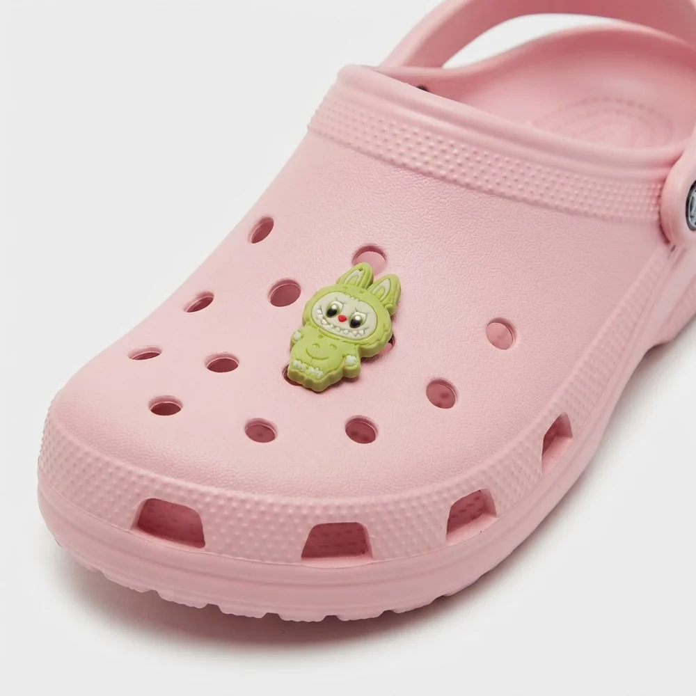 Jibbitz Labubu vert debout, clipsé sur une Crocs