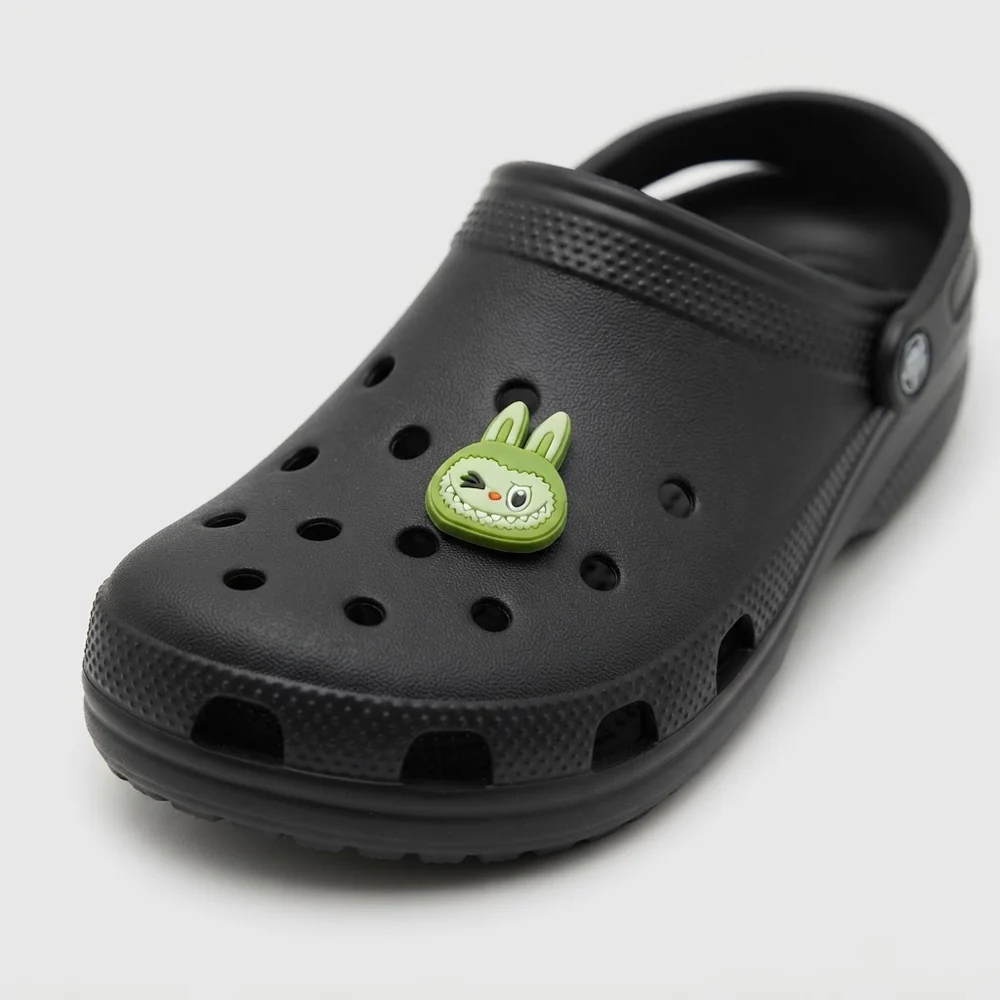 Tête de Labubu verte clin d'œil clipsée sur une Crocs