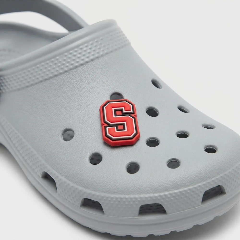 Jibbitz lettre S rouge clipsé sur une Crocs