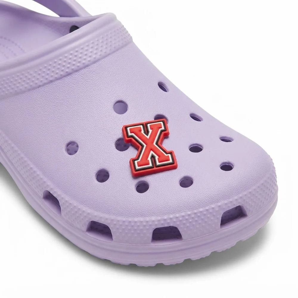 Jibbitz lettre X rouge clipsé sur une Crocs