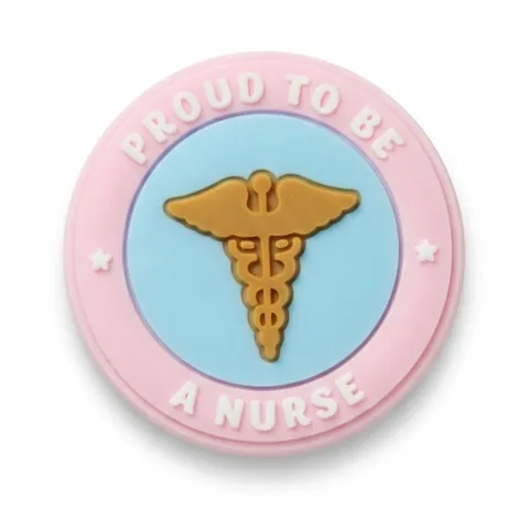 Jibbitz badge rond rose Proud to Be a Nurse avec caducée doré sur fond bleu ciel