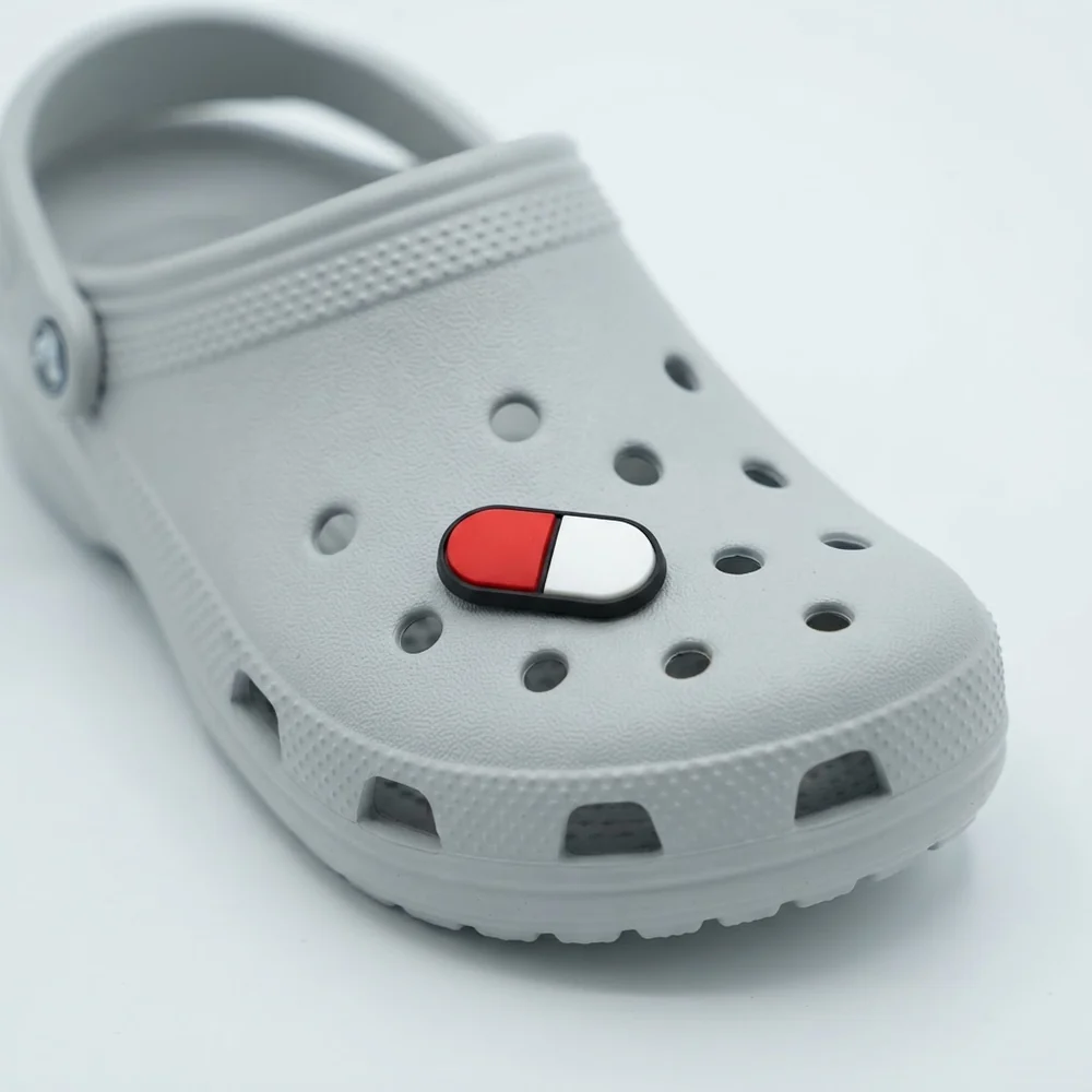 Jibbitz gélule rouge et blanche clipsé sur une Crocs