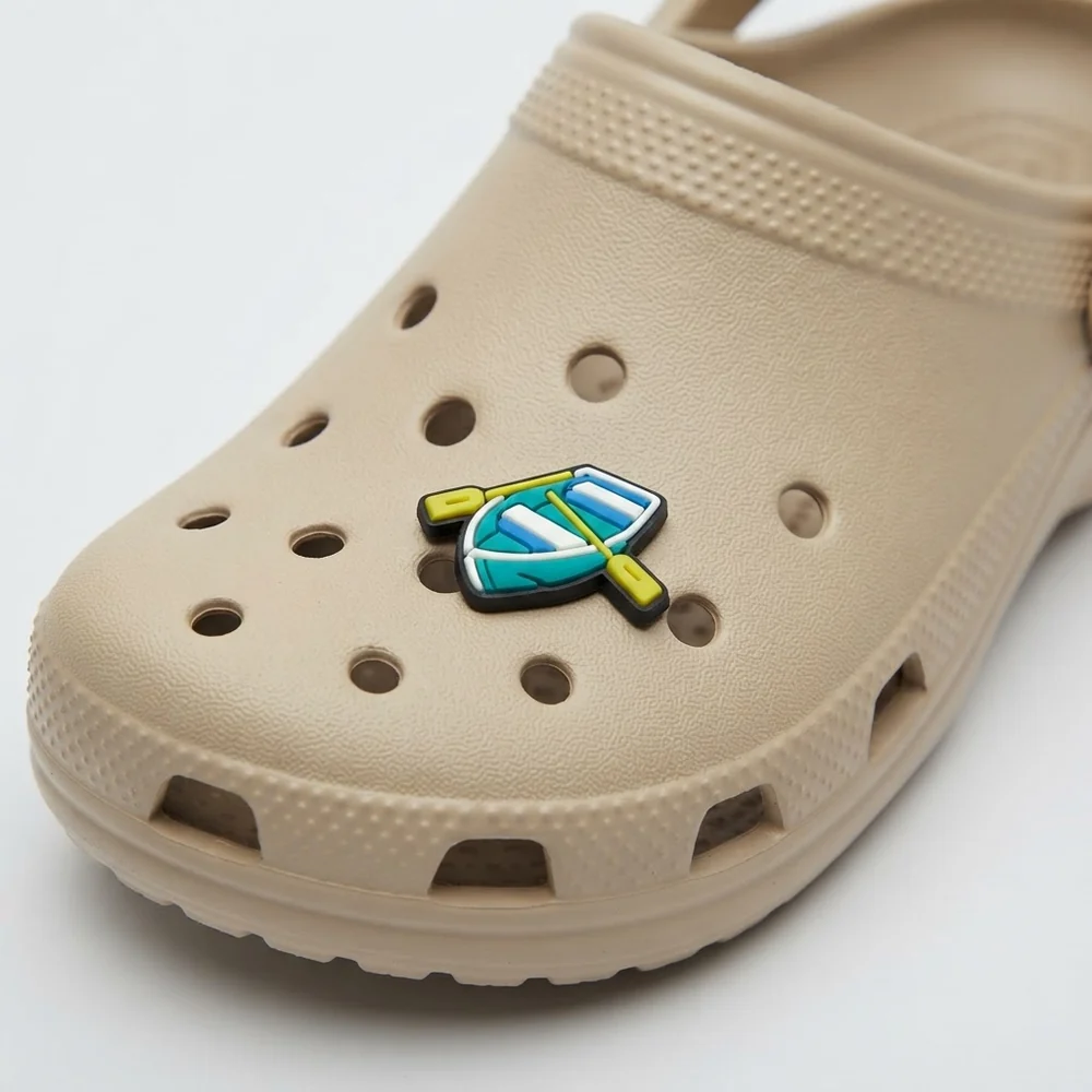 Jibbitz barque turquoise à rames jaunes clipsé sur une Crocs