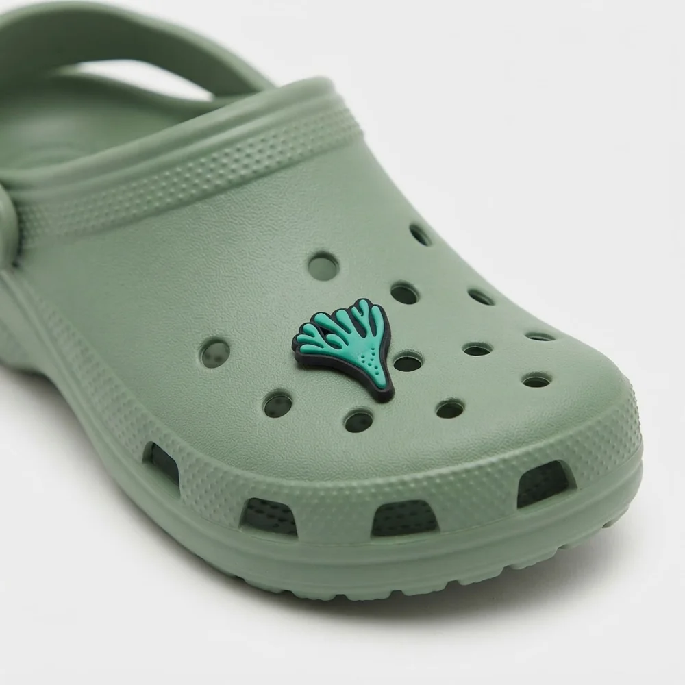 Jibbitz corail turquoise clipsé sur une Crocs