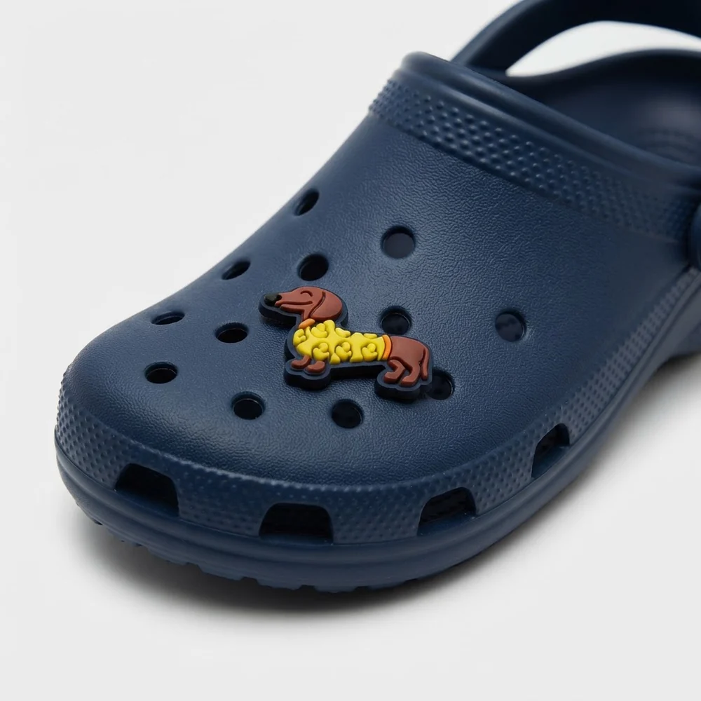 Charm teckel en pull jaune porté sur une Crocs